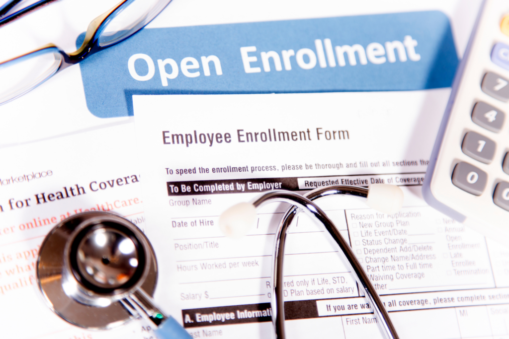 Image of an Employee Enrollment Form with a stethoscope on it and "Open Enrollment" written behind it.